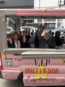 Guests waving from a VIP Hollywood Tours sightseeing bus during a guided tour of Hollywood in Los Angeles.