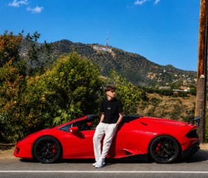 Guest posing beside a red Ferrari California T with the Hollywood Hills in the background during a Ferrari driving experience in Los Angeles.